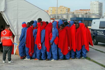 Varios inmigrantes forman fila tras desembarcar en Málaga este martes.