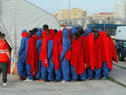 Varios inmigrantes forman fila tras desembarcar en Málaga este martes.