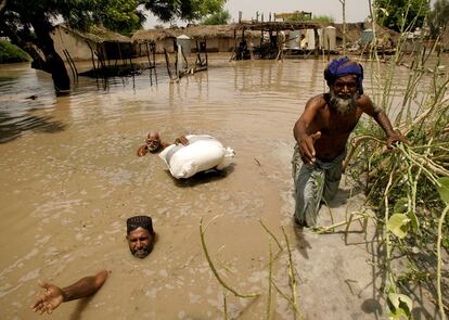 Supervivientes de las inundaciones intentan hacerse con ayuda distribuida por el Ejército en la localidad de Sangi, cerca de Sukur, al sur de Pakistán.