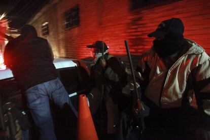 Men belonging to a community police force patrol the area near the Raul Isidro Burgos de Ayotzinapa Teachers College in the town of Tixtla, in the state of Guerrero, Mexico, late Sunday Oct. 12, 2014. The community police is securing the area around the school and is also helping in the search for the 43 students that went missing after a confrontation with local police that left 6 dead. The missing students have not been found, though 26 local police officers have been detained, and officials are attempting to determine if any of newly discovered mass graves contain the bodies of the students. (AP Photo/Felix Marquez)