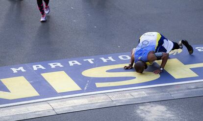 Cedric King, que perdió ambas piernas en Afganistán, besa el suelo en la meta del maratón después de correr con el equipo MR8, llamado así por la víctima más joven, Martin Richard, del atentado en el maratón de Boston de 2013.