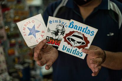 Un vendedor muestra 'stickers' de las tres pandillas más populares en Monterrey dentro del ambiente de la música de la ciudad.
