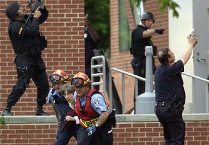 La policía evacúa a una de las 70 personas atrapadas en el edificio donde se atrincheró el francotirador.