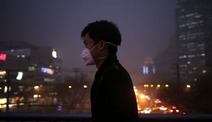 Un hombre pasea por las calles de Pek&iacute;n (China) con una mascarilla.