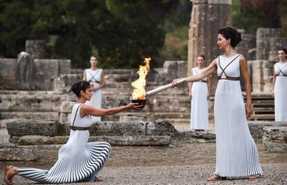 La actriz Katerina Lechou (dcha.), que interpreta a la suma sacerdotisa, enciende la llama olímpica en el templo de Hera, en Olimpia (Gracia).