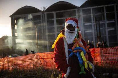 Un migrante africano vestido de Pap Noel frente a la fbrica abandonada durante la evacuacin.