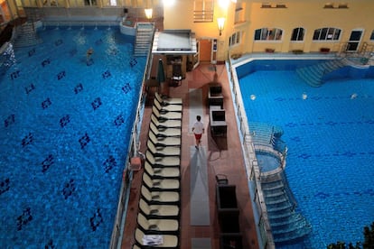 Un socorrista camina entre dos piscinas en el Balneario Lukacs.