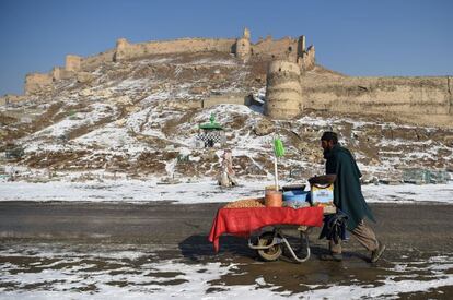 Un vendedor afgano empuja una carretilla después de la primera nevada cerca de la antigua fortaleza de Bala Hissar, en Kabul.