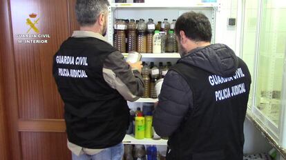 Dos agentes de la Guardia Civil durante el registro de una de las f&aacute;bricas. 