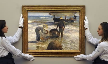 Dos empleadas de la casa de subastas Sotheby's preparan la obra "Pescadores valencianos", de Joaquín Sorolla