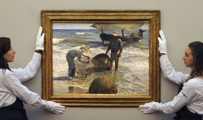  Dos empleadas de la casa de subastas Sotheby&#039;s preparan la obra &quot;Pescadores valencianos&quot;, de Joaqu&iacute;n Sorolla