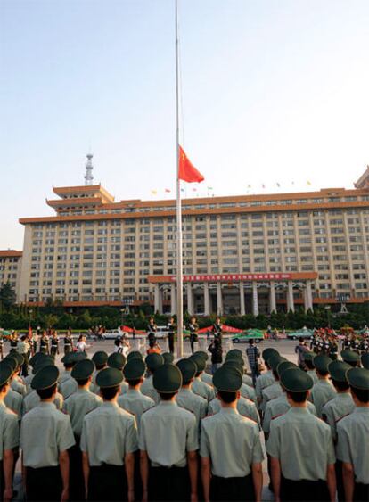 Oficiales del Ejército chino guardan silencio con la bandera a media asta en la provincia de Shannxi.