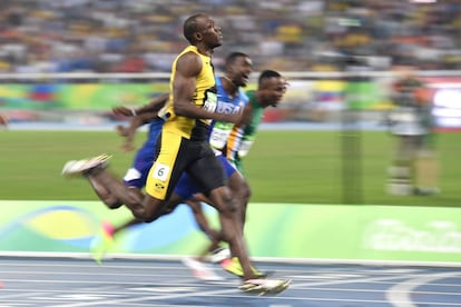 Bolt cruza la meta para ganar su tercer oro en los 100 m lisos.