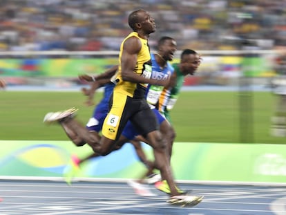 Bolt cruza la meta para ganar su tercer oro en los 100 m lisos.