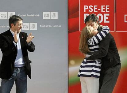 Trinidad Jiménez abraza a Eduardo Madina, cabeza de lista al Congreso por Vizcaya, ante la mirada de Patxi López, en el mitin de Portugalete.