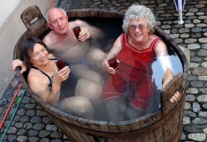 Katharina, de 72 años, Erich, de 80, y Gerharda, de 71, disfrutan de un baño en una antigua bañera instalada en el patio de un museo en Basilea, Suiza.