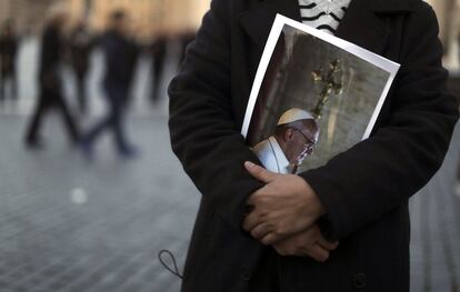 Un hombre sujeta un retrato del papa Francisco en la plaza de San Pedro, durante la primera misa del pontífice en la capilla Sixtina.