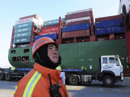 Un operario del puerto de la ciudad china de Qingdao cerca de un buque portacontenedores.