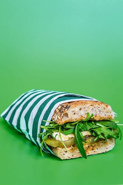 <p><b>El pesto</b> que sobre de esta preparación se puede conservar en la nevera y usar para aliñar pastas o ensaladas (aligerado con un poco más de aceite y zumo de limón). Este bocadillo se puede tomar caliente o del tiempo, así que es perfecto para comer en el trabajo o para excursiones.</p> <p><em>Ingredientes: Para un bocadillo. ½ barra (unos 120 gramos) de pan de cereales, un tomate verde, ½ bola de mozzarella fresca de búfala, ½ taza de rúcula, 2 cucharadas de pesto rojo, que se preparará con 10 tomates deshidratados, ½ diente de ajo (al natural o escalivado), 3 cucharadas de piñones, 50 mililitros de aceite de oliva virgen extra, 12 hojas de albahaca, 30 gramos de parmesano rallado.</p></em> <p><em>Preparación:</em> Elaborar el pesto mezclando todos los ingredientes en el vaso de la batidora. Cortar el tomate en rodajas, pasarlo por la plancha a fuego alto sin aceite o con el mínimo posible. Montar el bocadillo poniendo un poco de pesto en la base, encima el tomate, después la <em>mozzarella</em> en rodajas y finalmente la rúcula. Terminar con más pesto, cerrar y servir.</p>