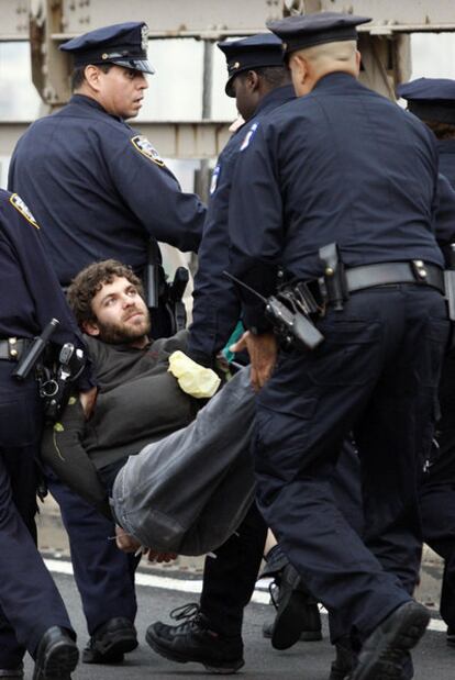 Un manifestante detenido mira a los agentes de policía en el puente de Brooklyn.