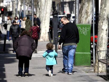 Unos padres pasan junto a su hija en el primer día sin colegio por el riesgo del coronavirus, en Madrid (España).