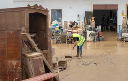 Los vecinos limpian una calle inundada por la dana, este jueves.