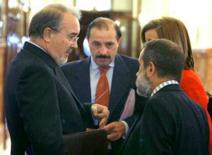 Solbes, a la izquierda, con el diputado del PP Vicente Martínez Pujalte, de frente, ayer en el Congreso.