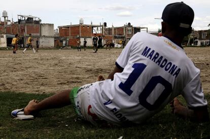 Aficionados al fútbol juegan en un campo, conocido por ser donde comenzó la leyenda del balompié Diego Armando Maradona en el barrio de su infancia, Villa Fiorito, a las afueras de Buenos Aires (Argentina).
