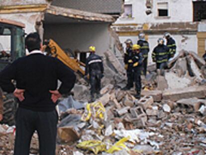 Los bomberos intentaban rescatar ayer el cuerpo del joven sepultado por los escombros del edificio.