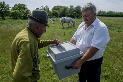 Un ciudadano húngaro recibe una urna para poder votar en un campo de Szentkiraly (Hungría).