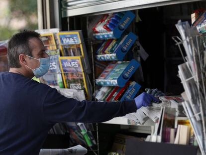 Un lector, protegido con mascarilla, compra periódicos en Bilbao durante la pandemia.