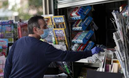 Un lector, protegido con mascarilla, compra periódicos en Bilbao durante la pandemia.