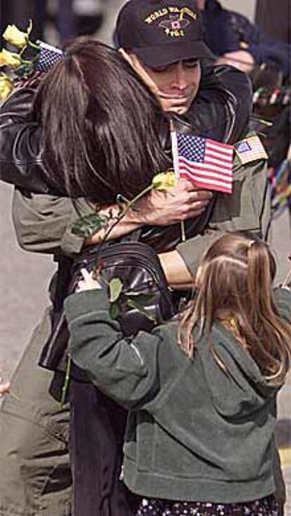Un tripulante del avión espía abraza a sus familiares en EE UU.