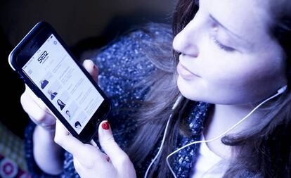 Una usuaria escucha con su móvil un 'podcast' de la Cadena SER.