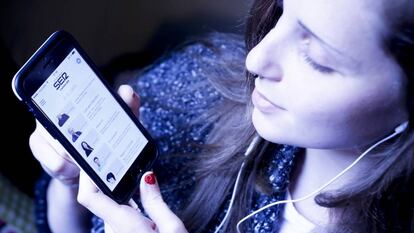 Una usuaria escucha con su móvil un 'podcast' de la Cadena SER.