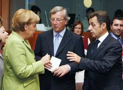 Jean-Claude Juncker (centro) conversa con Angela Merkel y Nicolas Sarkozy en Bruselas.