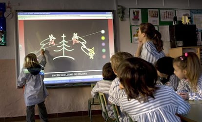 Alumnes de primària de l'escola Sant Jordi de Vilassar de Dalt (Barcelona) utilitzen una pissarra digital.