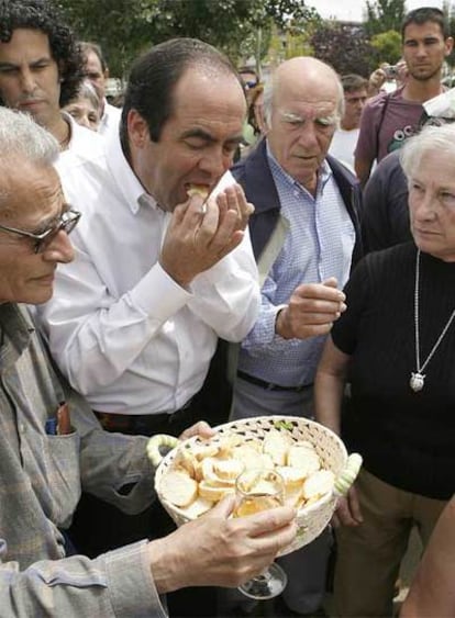 José Bono comulga ante la atenta mirada (detrás) de Pedro Zerolo