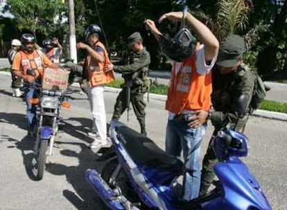 La policía cachea a unos motoristas en la entrada del aeropuerto de Vanguardia de Villavicencio.