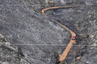 Un camión de bomberos circula por la carretera de una zona calcinada debido a un incendio en Carnoux-en-Provence (Francia).