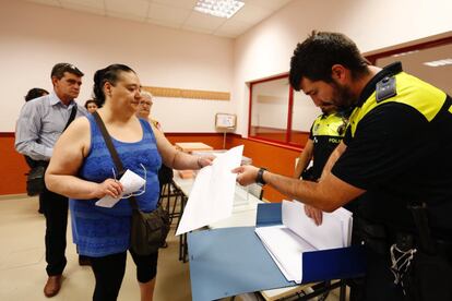 La labor de todos ellos comienza el día de la votación a las 08.00 horas. La cita es para el presidente y los dos vocales elegidos, pero también para los suplentes, que tienen que acudir al colegio electoral por si fallan los titulares, lo que supone una movilización en total de 517.734 344.916 personas en todo el país. En la imagen, un agente de policía entrega las listas electorales a un miembro de la mesa electoral en un instituto de Madrid.