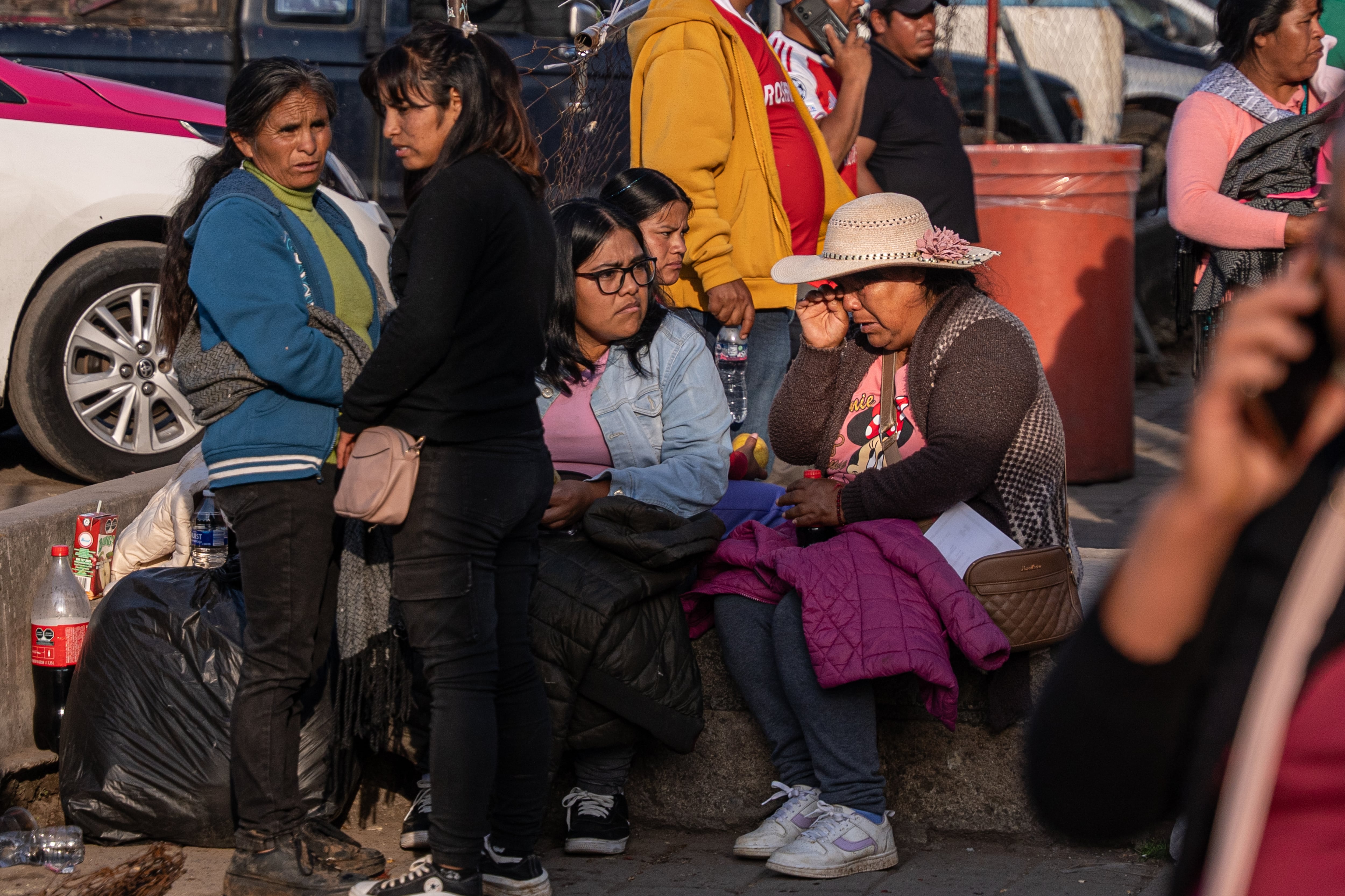 Florencia Ascencio, de sombrero, espera junto a sus hijas afuera del hospital.