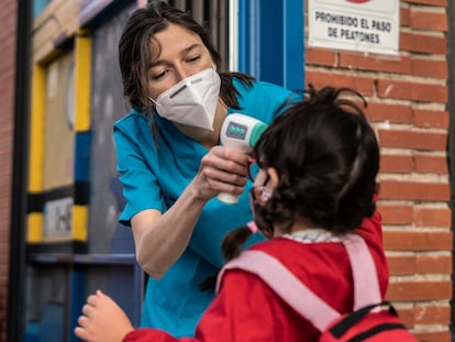 Una trabajadora del colegio público Tomás Bretón toma la temperatura de los menores antes de entrar.