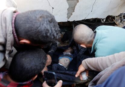 Varias personas rescataban el cuerpo de un niño atrapado entre los escombros de un edificio destruido tras un ataque israelí, este lunes en Rafah, en el sur de la franja de Gaza. 