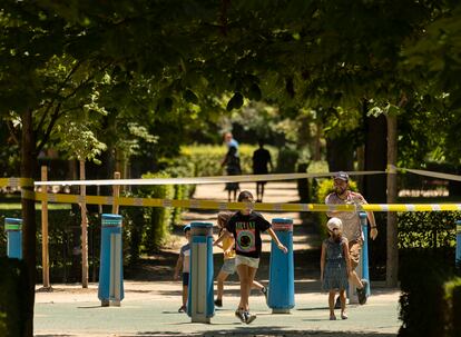 Una familia juega dentro de un área balizada en el parque de El Retiro, el pasado martes.