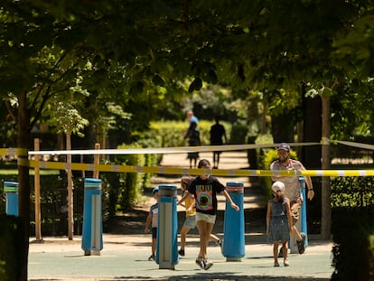 Una familia juega dentro de un área balizada en el parque de El Retiro, el pasado martes.