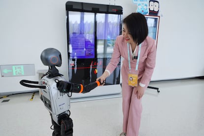 Un robot humanoide Booster T1 estrecha la mano de un periodista en el Centro Internacional de Innovación de Zhongguancun, el pasado 26 de marzo.