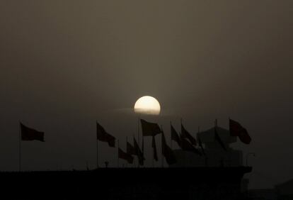 The sun rises as red flags on the roof of the National Museum flutter at Tiananmen Square ahead of the opening session of the National People's Congress (NPC) in Beijing, China, March 5, 2016. REUTERS/Kim Kyung-hoon      TPX IMAGES OF THE DAY     