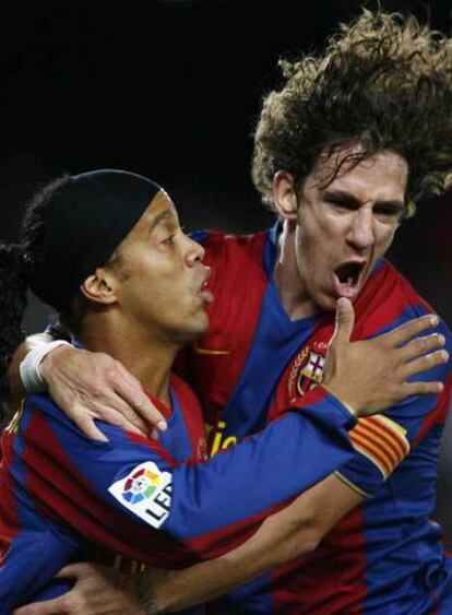 Ronaldinho y Puyol celebran un gol.