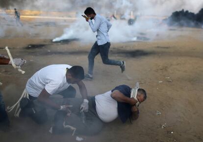 Manifestantes palestinos reaccionan al gas lacrimógeno lanzado por las tropas israelíes, el 12 de octubre de 2018, en la Franja de Gaza.  